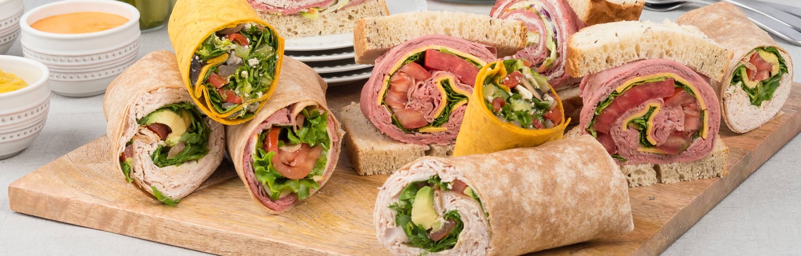 Catering wraps and sandwiches on a cutting board