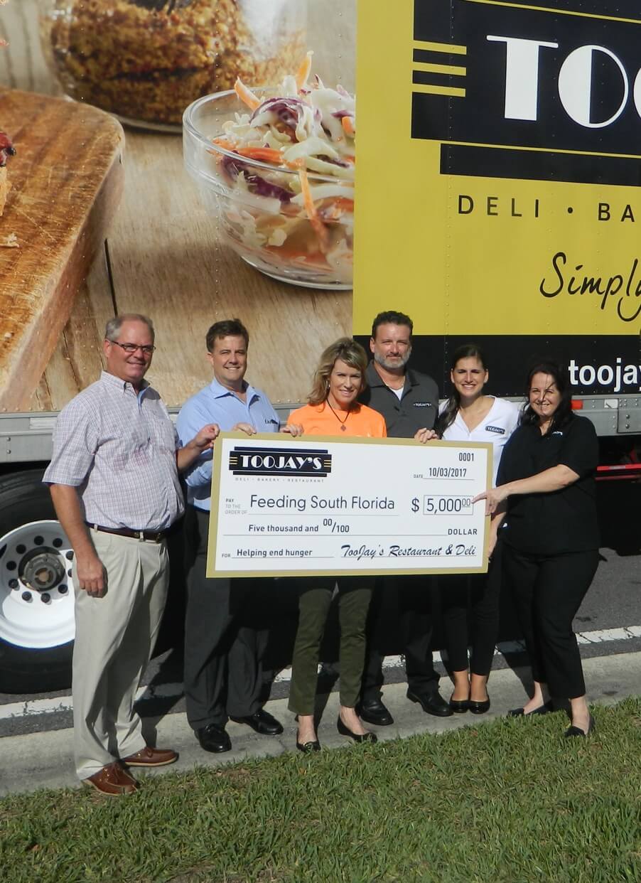 Employees presenting Feeding South Florida donation check