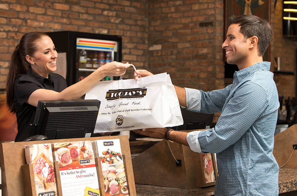 Man picking up to-go food from TooJay's