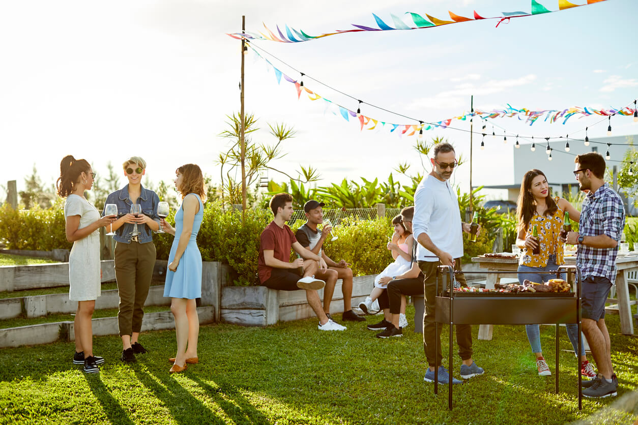 Creative party idea. Outdoor gathering on a roof with people mingling and barbeque