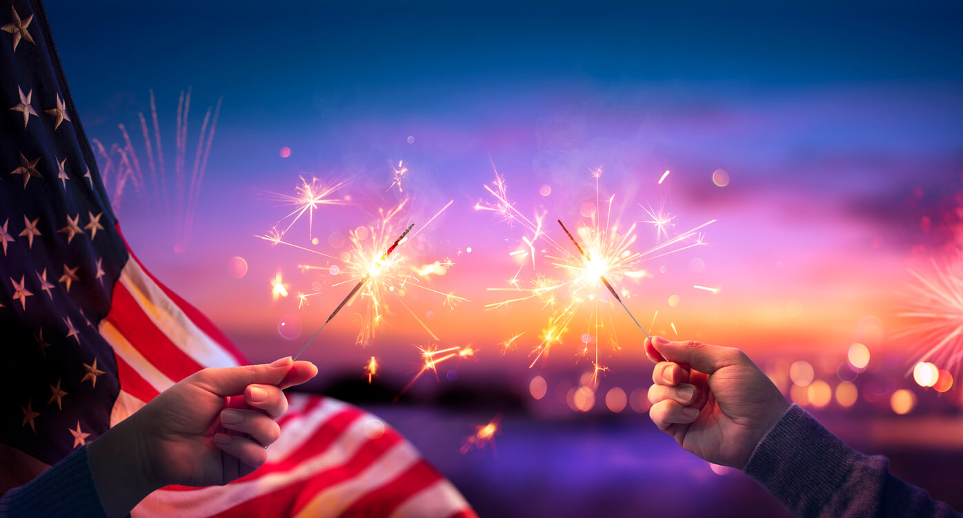 Guests enjoy waving sparklers at a fun 4th of July party